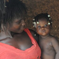 Une mère africaine regarde sa petite fille dans les bras avec tendresse